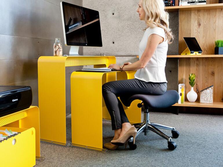 Der Tisch hebt den Monitor auf eine ergonomische Höhe