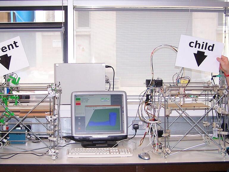 Das erste Mal, dass eine RepRap-Maschine sich selbst gedruckt hat. Adrian Bowyer (links) und Vik Oliver (hat die erste Kopie erstellt). Die „Kind“-Maschine erstellte erfolgreich den ersten Teil des „Enkels“ am 29 Mai 2008 an der Universität von Barth.