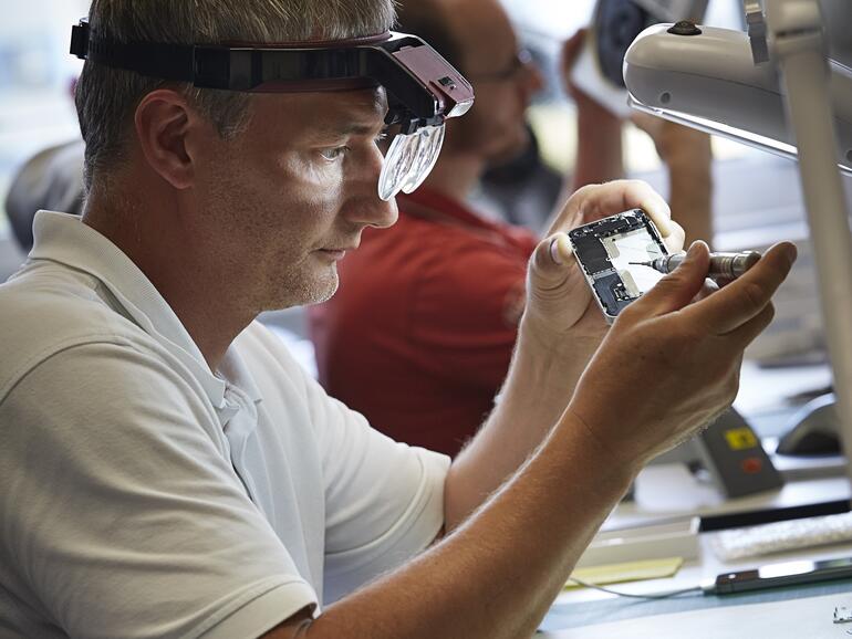 Ein Techniker von AsGoodAsNew bei der Instandsetzung eines iPhones