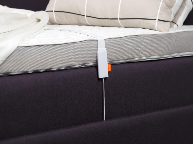 Der Tracker besteht aus einem dünnen Sensorstreifen, an dessen Ende sich ein kleiner Plastikkasten befindet. Dieser muss an den Strom angeschlossen werden.