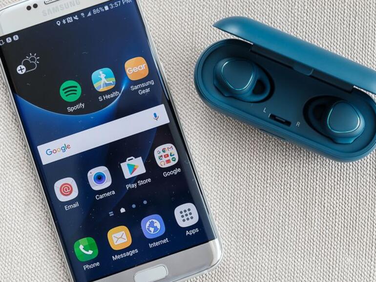 Samsung Gear IconX Kopfhörer neben Galaxy S7 Edge.