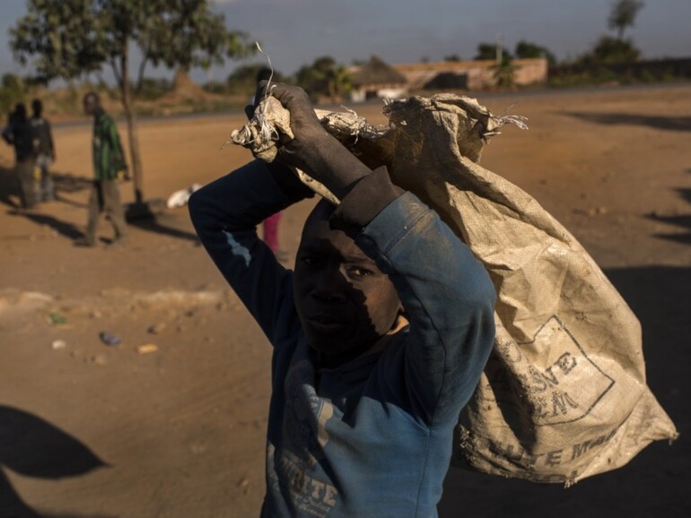 Ein arbeitender Junge schleppt einen Sack in der Nähe einer Kobalt-Mine