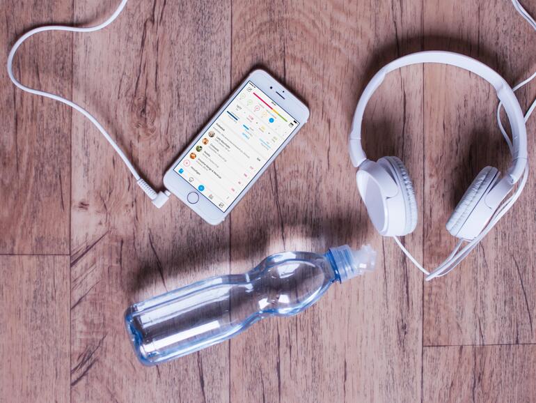 Musik am Smartphone per Kopfhörer motiviert beim Training, Mineralwasser löscht den Durst