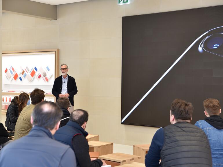 Bei Workshops steht ein Dozent vor den Zuschauern im Forum des Apple Store