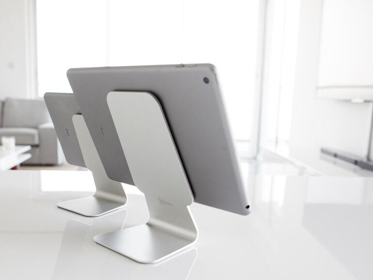 Klebestativ: Der Slope ist ein an Minimalismus kaum zu übertreffender iPad-Halter. Er besteht im Wesentlichen aus einem knapp 30 Zentimeter langen und 250 Gramm leichten Stück gebürsteten Aluminium. Auf dem sich nach oben hin verbreiternden Hals ist eine schwarze Gummifläche aufgebracht, eine weitere findet sich unter dem Fuß. Diese Gummiflächen sind mit Nanoschaum überzogen, dessen Lufttaschen wie Saugnäpfe an glatten Oberflächen haften. So kann man den Slope fast unverrückbar auf einer Tischplatte abstellen und ein auf dem Hals abgelegtes iPad bleibt dort trotz des steilen Winkels sicher haften. Mit wenig Kraftaufwand kann man die sicheren Bindungen wieder lösen. Sollten die Gummiflächen durch Verschmutzung an Haftkraft einbüßen, kann man diese mit Wasser reinigen oder schließlich auch austauschen.