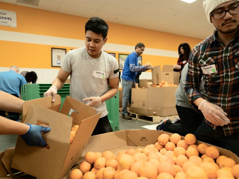 Apple-Mitarbeiter sortieren Orangen in der Second Harvest Food Bank in San Jose, Kalifornien.
