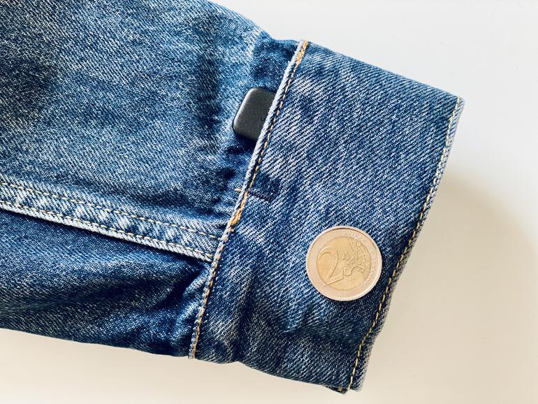 In der Manschette des linken Ärmels steckt die Technik – neben dem Port für den kleinen Jacquard-Dongle entdeckt man eine Art Plakette von etwas mehr als der Größe eines 2 Euro Stücks. Die beiden Teile sind beim Tragen kaum zu spüren und stören nicht. Maschinenwaschbar ist das Ganze natürlich trotz der Technik im Ärmel.