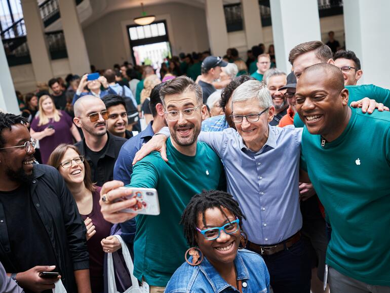 Apple CEO Tim Cook, blaues Hemd, im Kreis seiner Angestellten bei der Eröffnung der Niederlassung Carnegie Library in Washington DC.