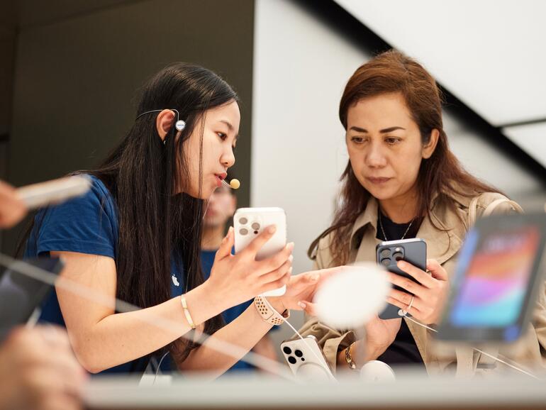 Kundin schaut sich iPhone 15 Pro Max im Apple Store an