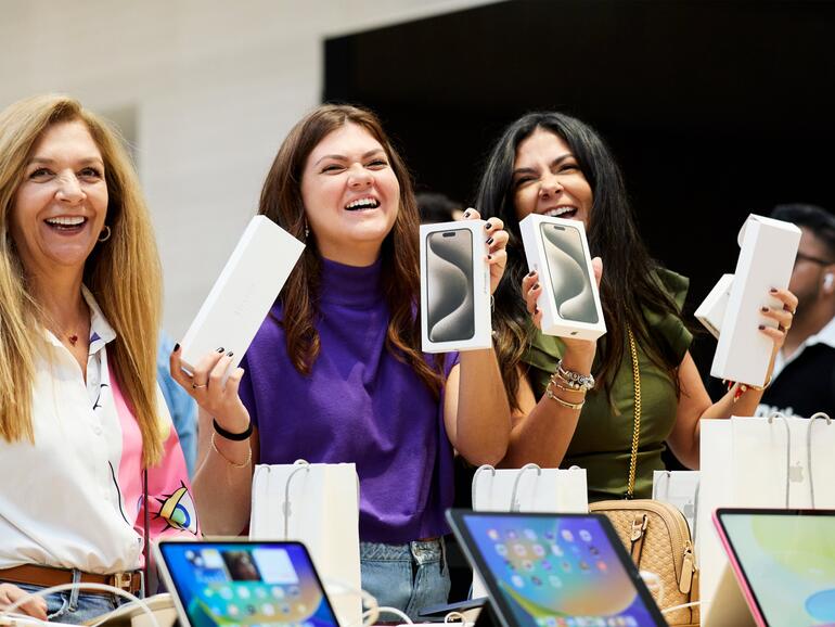 Kundinnen im Apple Store halten ihr neues iPhone in der Hand