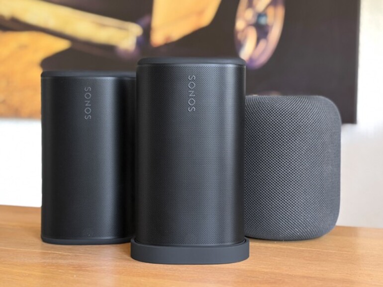 Größenvergleich: Der Sonos Play (Mitte, auf Ladeschale) zwischen einem Sonos Roam (links) und einem Apple HomePod (rechts) – kompakter als erwartet, aber deutlich wuchtiger als der kleine Bruder.