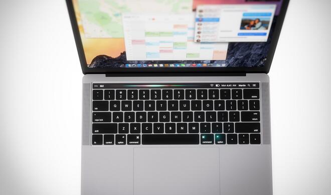 Siri in OLED-Touchleiste am MacBook Pro mit Bedienelementen und Songinformationen.