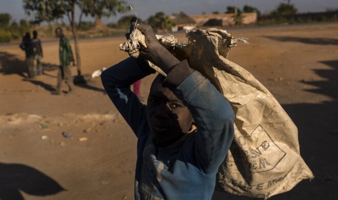 Ein Junge schleppt einen Sack mit Kobalt