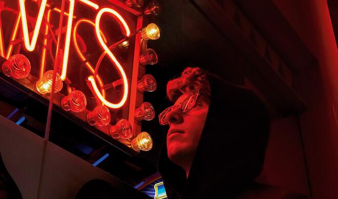 Mit dem iPhone 7 (Plus) aufgenommen: Person vor Leuchtreklame