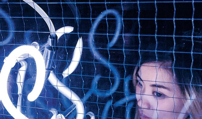 Mit dem iPhone 7 (Plus) aufgenommen: Junge Frau hinter Leuchtreklame