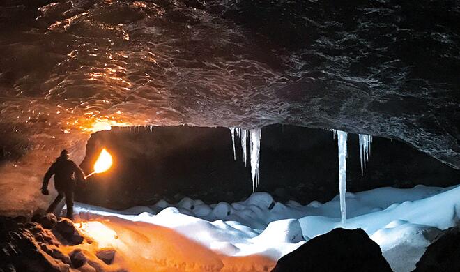 Mit dem iPhone 7 (Plus) aufgenommen: Mann mit Fackel in Höhleneingang bei Nacht