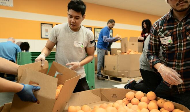 Apple-Mitarbeiter sortieren Orangen in der Second Harvest Food Bank in San Jose, Kalifornien.