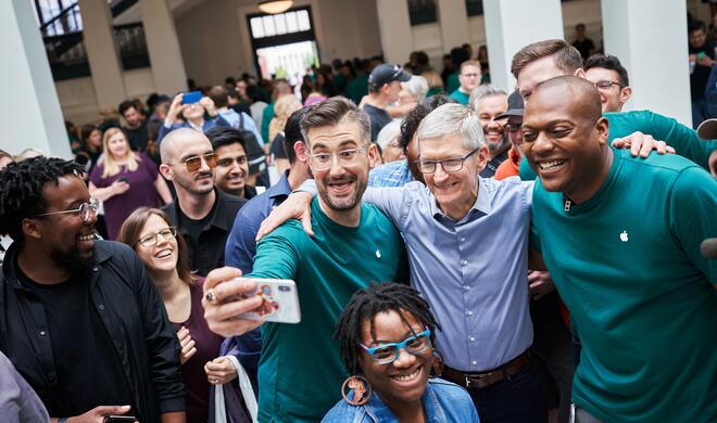 Apple CEO Tim Cook, blaues Hemd, im Kreis seiner Angestellten bei der Eröffnung der Niederlassung Carnegie Library in Washington DC.