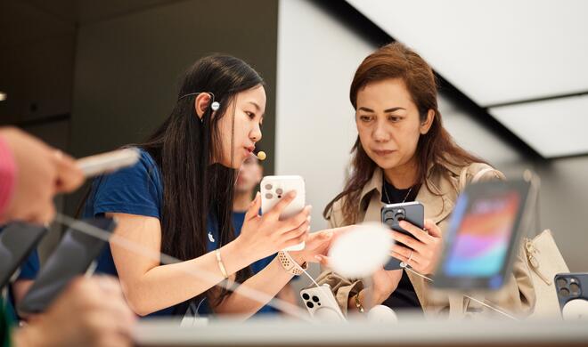 Kundin schaut sich iPhone 15 Pro Max im Apple Store an